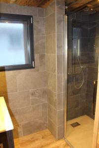 een douche met een glazen deur in een badkamer bij chalet bel horizon La Montagne Des Lamas in La Bresse
