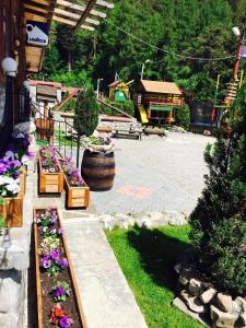 einen Garten mit Blumen in einem Hof mit einem Gebäude in der Unterkunft Chalet Il Rifugio Bradet in Săcele