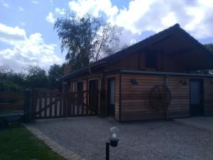Cabaña de madera con puerta y valla en Le Carport, en Hasnon