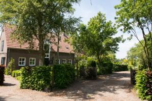 una casa con árboles y un camino de entrada en Gastenverblijf Het Voorhuis, en Herpen