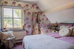a bedroom with a bed and a window at Gastenverblijf Het Voorhuis in Herpen