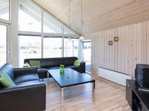 a living room with a couch and a table at Four-Bedroom Holiday home in Idestrup 3 in Marielyst