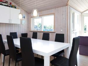 a dining room with a white table and chairs at 9 person holiday home in V ggerl se in Bøtø By