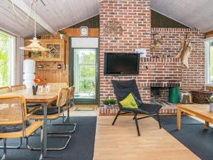 a dining room with a table and chairs and a brick wall at 6 person holiday home in Knebel in Knebel