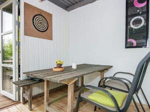 a wooden table and chairs in a room at 6 person holiday home in Knebel in Knebel