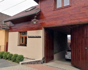 uma casa vermelha e branca com uma porta de madeira em Apartmán Trstinka em Trstené