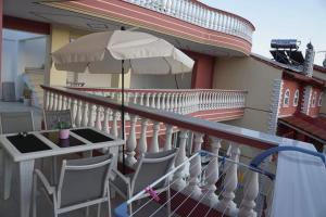 a balcony with a table and chairs and an umbrella at petros house in Sarti