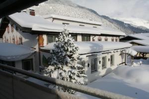 una casa ricoperta di neve con un albero di Natale di Wanderhotel Grüner Baum a Bach