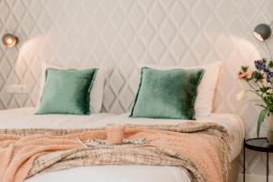 een slaapkamer met 2 bedden en groene kussens bij Hotel Steeds aan Zee in Katwijk