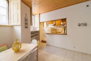 eine Küche mit weißen Wänden und einer Holzdecke in der Unterkunft Casa confortável no centro da cidade in Figueira da Foz
