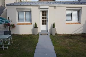 una casa bianca con un sentiero che porta alla porta d'ingresso di Maison de standing avec jardin à 200m de la plage a Berck-sur-Mer