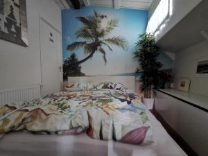 a bedroom with a bed with a palm tree mural at Waterloo square river vieuw houseboat in Amsterdam