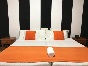 1 cama grande con almohadas de color naranja y blanco en Hotel Argos, en Calasparra