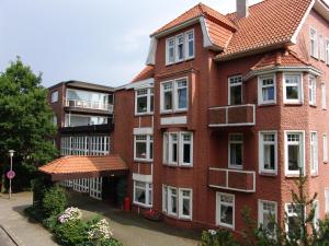 a red brick building with white windows at Hotel Wehrburg in Cuxhaven