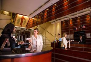 a woman standing at a counter in a bar at Attalos Hotel in Athens