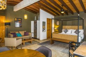 Hotel Amate del Rio في مالينالكو: غرفة نوم مع سرير وغرفة معيشة