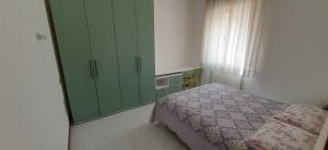 a bedroom with a bed and a green cabinet at Appartamento Raffaello in Cattolica