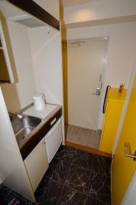 a small kitchen with a sink and a shower at Melody Heim 2C in Tokushima