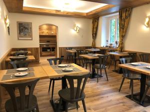 a restaurant with wooden tables and chairs and a piano at Hotel Seerose Wolfgangsee in St. Wolfgang