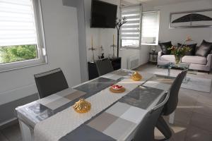 a dining table and chairs in a living room at Appartement de standing in Berck-sur-Mer
