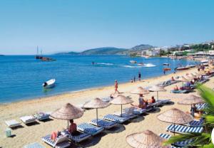 uma praia com um monte de cadeiras e guarda-sóis em Villa em Bodrum City