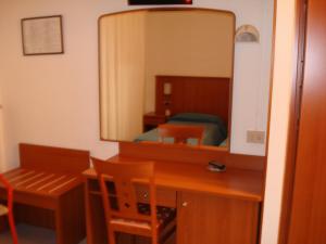 - une chambre avec un bureau et un miroir dans l'établissement Hotel Aquilia, à Laigueglia