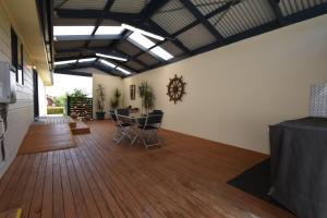 a room with a table and chairs on a wooden floor at The Lazaret in Kingscote