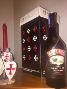 a bottle of whisky next to a box on a table at Templar Secrets House in Tomar