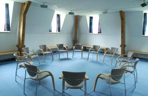 een kamer met een rij stoelen en tafels bij Tagungshaus Reimlingen in Reimlingen