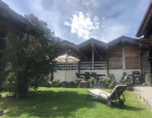 a yard with a chair in front of a house at The cosy Isba - Chambre d hôtes - Val de Bagnes - Verbier in Versegeres 