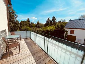 a balcony with a table and a chair on a deck at Ferienwohnungen Weingut Kilburg in Brauneberg
