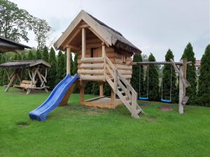 mały drewniany plac zabaw ze zjeżdżalnią i huśtawką w obiekcie Pod Koziorożcami w mieście Trzebiechów