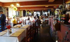 a restaurant with people sitting at tables in a bar at Casa Magica Busteni in Buşteni