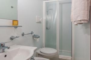 a bathroom with a shower and a toilet and a sink at Albergo De Jean in Garzeno