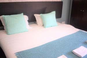Una cama con almohadas azules y blancas. en Universo Romantico en Lisboa