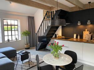 a kitchen and a living room with a table in a room at Appartement de Lerarenkamer in de Oude School in Heerlen