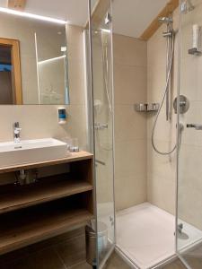 a bathroom with a shower and a sink at Ländle Hotel in Damuls