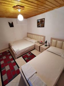 una camera con 2 letti e un soffitto in legno di Tomor Shehu Guest House a Berat