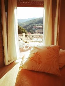 Cama frente a una ventana con vistas en Hotel Eva La Romantica en Moneglia