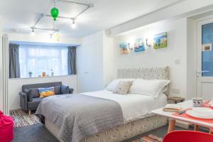 um quarto com uma cama, uma cadeira e uma mesa em The Studio @ 93 Bernard Rd em Brighton & Hove