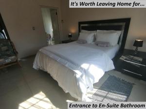 1 dormitorio con 1 cama grande con sábanas y almohadas blancas en Charlie's Spot - Norwood, en Johannesburgo