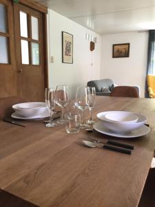 una mesa de madera con platos y copas de vino. en De Skure en Harelbeke