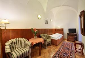 ein Hotelzimmer mit einem Bett und einem Tisch und Stühlen in der Unterkunft Hotel Konvice in Český Krumlov