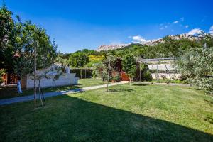 a garden with trees and mountains in the background at Apartment Pirun in Baška
