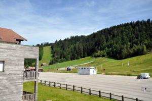 um parque de estacionamento com um edifício e uma colina em La perle du Grand Haut em Gérardmer