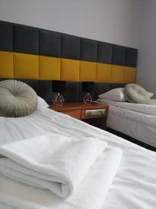 1 dormitorio con 2 camas con sábanas blancas en Platinum, en Budzyń