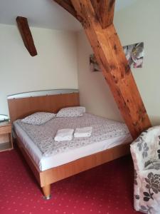 1 dormitorio con 1 cama con 2 toallas en Hotel pod Muzami en Kamień Pomorski