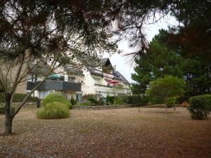 a large white house in a park with trees at Studio LUMINEUX avec belle TERRASSE sur ESPACES VERTS, 100m PLAGE in Carnac-Plage