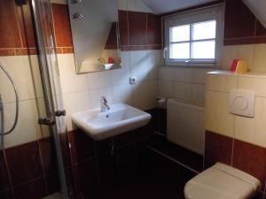 łazienka z umywalką, toaletą i oknem w obiekcie Eiscafe&Pension Schumann w mieście Bresewitz