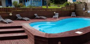 una gran piscina con sillas y una terraza en Coeur Caraibes en Deshaies